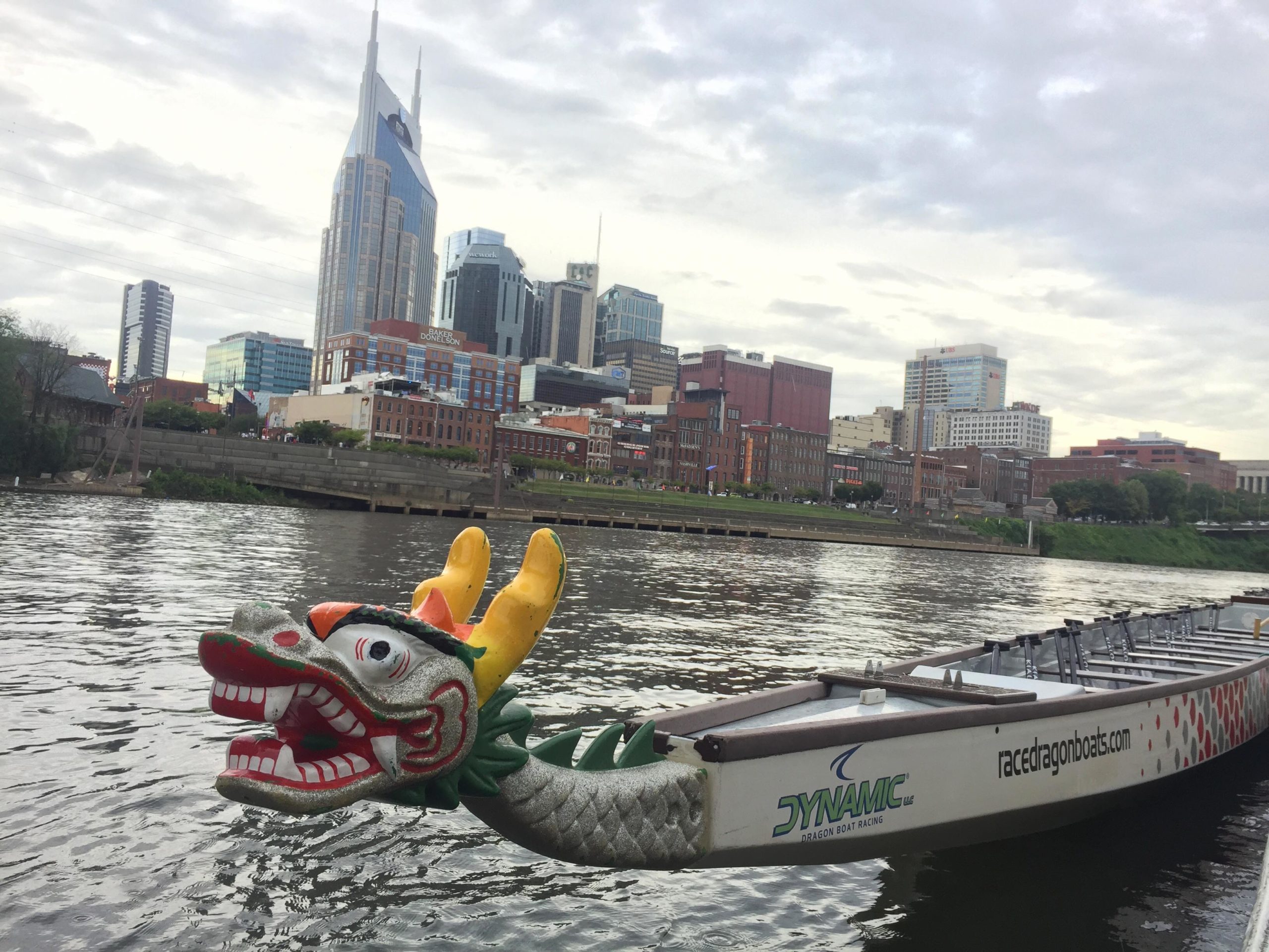 a small boat in a body of water with a city in the background