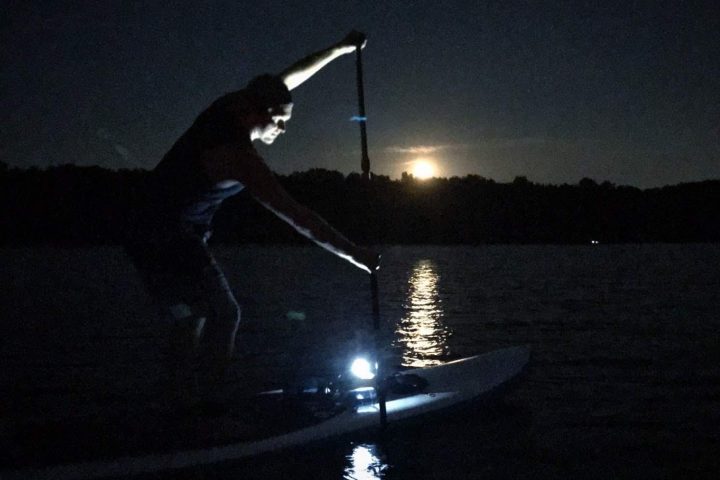 a person flying through the air over a body of water