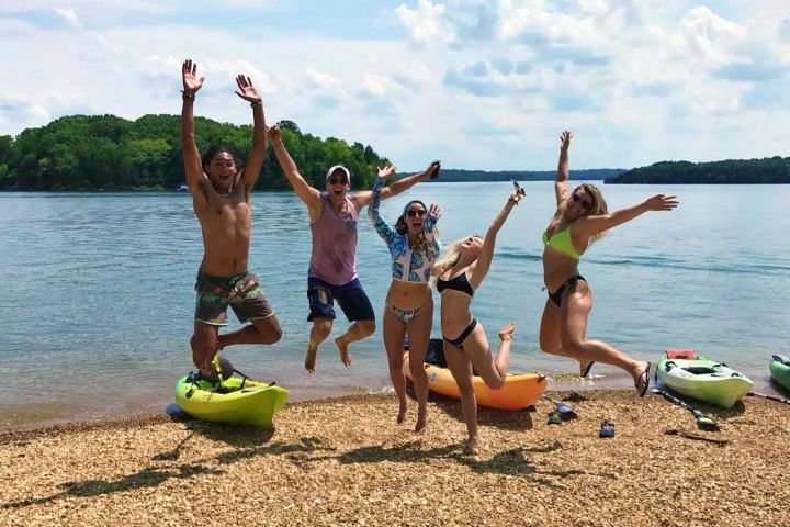 a group of people on a beach near a body of water