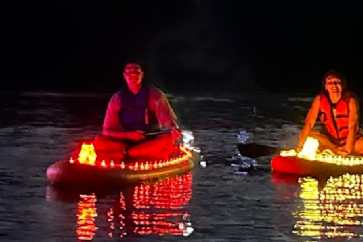 a man riding on the back of a boat in the water